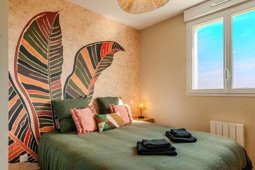 a bedroom with a bed with a large painting on the wall at Le Repère du Douanier - Séjour pro, calme et cosy in Mayenne