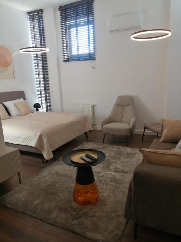 a living room with two beds and a table at Apartament 60 in Koszalin