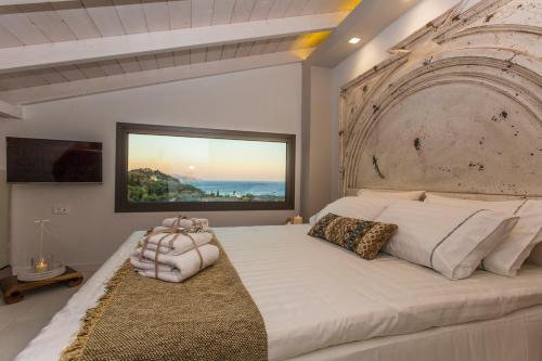 sypialnia z dużym łóżkiem z dużym zagłówkiem w obiekcie Golden Bay Suites & Maisonettes w mieście Parga
