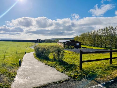 ハヴォルスヴォルールにあるホテル エイヤフィヤトラヨークトルの納屋と柵のある野原の小道