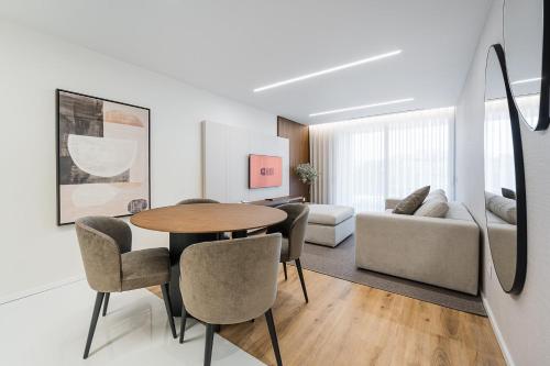 a living room with a table and chairs and a couch at GuestReady - Beach and Pool Escape in Gaia in Vila Nova de Gaia
