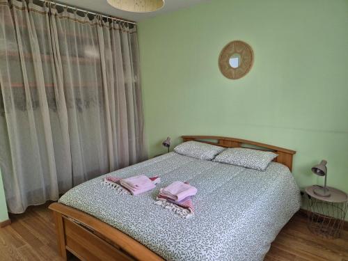 a bedroom with a bed with two towels on it at Maison chaleureuse au calme in Domérat