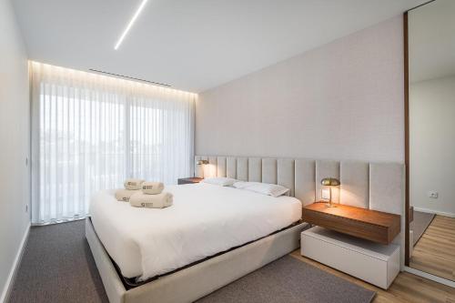 a bedroom with a large bed and a large window at GuestReady - Beach and Pool Escape in Gaia in Vila Nova de Gaia