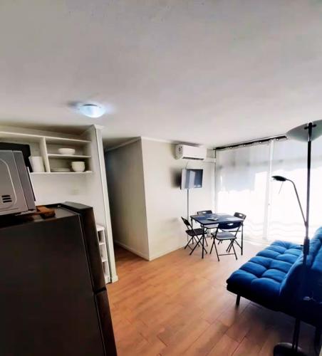 a living room with a table and a blue couch at Apartamento moderno - Metro a 3 min - 2 dormitorios in Santiago