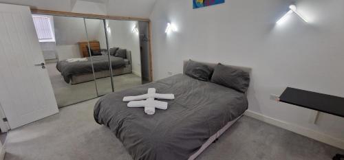 een slaapkamer met een bed met een teddybeer erop bij Solid Mirror Home Milton Keynes in Bletchley