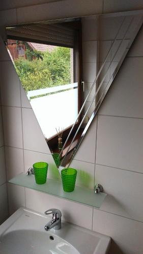 a bathroom with a sink and a window with green baskets at Haus Ruf in Windischgarsten