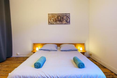 a bedroom with a bed with blue pillows on it at La POP HOUSE, Netflix, Wi-Fi Fibre, 6 couchages in Amiens