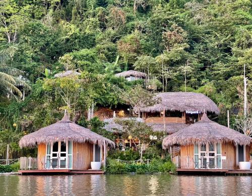 a group of huts on a body of water at Jantara Resort and Restaurant in Suratthani