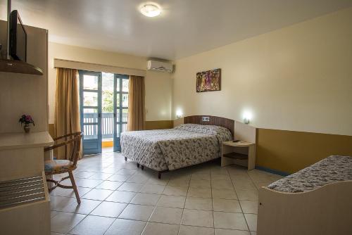 een hotelkamer met twee bedden en een balkon bij Vila Olaria Hotel in Penha