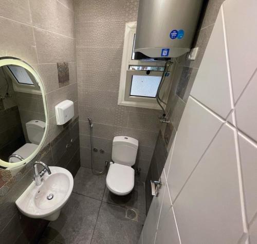 une salle de bain avec toilettes, lavabo et miroir dans l'établissement مدينتي القاهرة الجديدة, à Madinaty