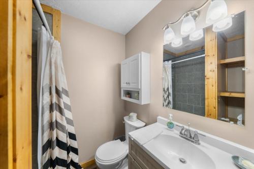 a bathroom with a sink and a toilet and a mirror at On Dolly Time Slow Down and Stay Awhile in Pigeon Forge