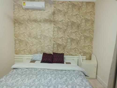 a bed with two pillows on it in a bedroom at Adelpha Properties,Abelenkpe accra in Abofu