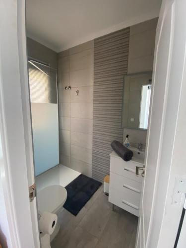 a bathroom with a white toilet and a sink at Casa iris in San Miguel de Salinas