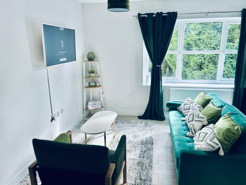 a living room with a blue couch and a window at Dover Ferry Apartments x 2 Sleeps 10 with parking and castle views in Kent