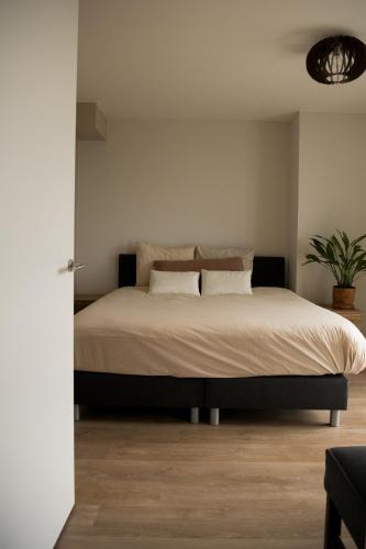 a bedroom with a large bed with two pillows at Suite Vuurtoren Zeeland in Scherpenisse