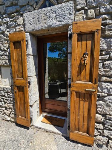 une porte ouverte d'un bâtiment en pierre dans l'établissement Chambre d'hôtes et de charme, à Labeaume