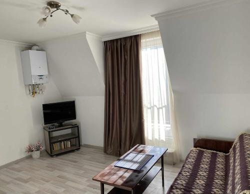 Una sala de estar con un sofá, un televisor y una mesa. en Wonderful View, en Tiflis