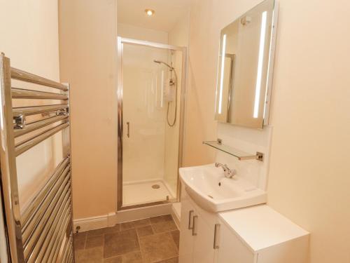 ein weißes Badezimmer mit Dusche und Waschbecken in der Unterkunft Flat 17 Greta Grove in Keswick