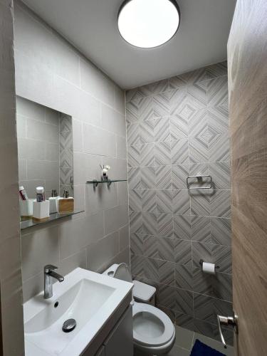 a bathroom with a toilet and a sink at Paradise away from home in Punta Cana