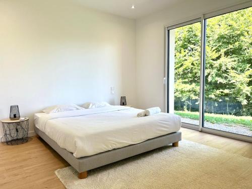 a bedroom with a large bed and a large window at La Rose, au calme aux portes de Limoges in Feytiat
