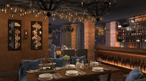 a dining room with a table and blue chairs at GREEN Which Hotel Kokshetau in Kokshetau