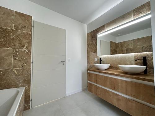 a bathroom with two sinks and a mirror at La Rose, au calme aux portes de Limoges in Feytiat