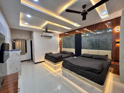 a bedroom with two beds and a ceiling fan at Maa Madhvadi Hotel & Restaurant in Mātānomadh