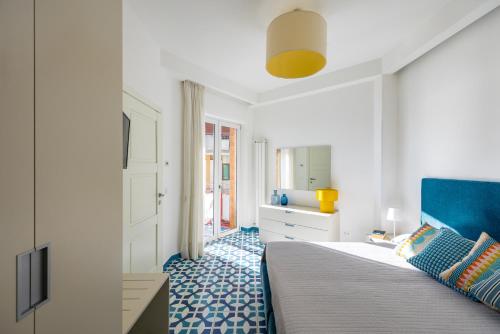 a bedroom with a bed with a blue headboard at Blumare Amalfi Coast in Maiori