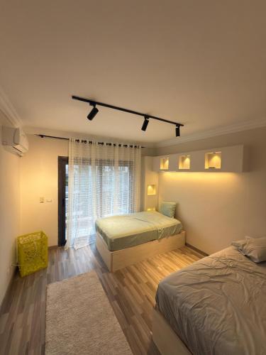 ein Schlafzimmer mit zwei Betten und einem Fenster in der Unterkunft مدينتي القاهرة الجديدة in Madinaty