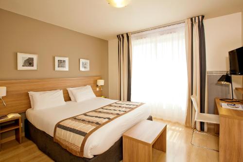 Cette chambre comprend un grand lit et une fenêtre. dans l'établissement Séjours & Affaires Paris-Vitry, à Vitry-sur-Seine