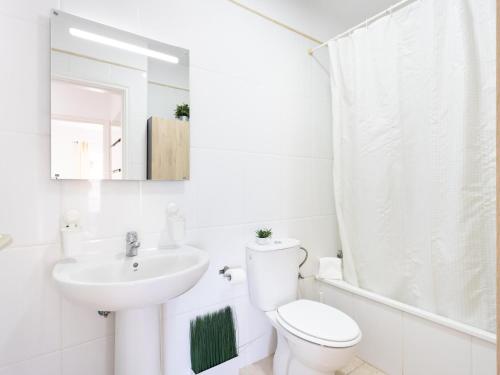 a white bathroom with a toilet and a sink at Puertito Azul in Puertito de Güímar