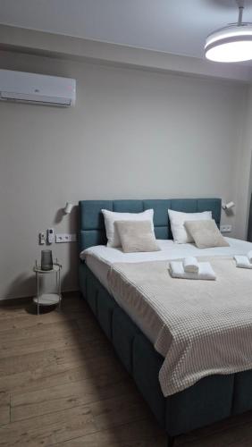 a large bed with a blue headboard in a room at WHITE HORTENZIA Guesthouse in Batumi