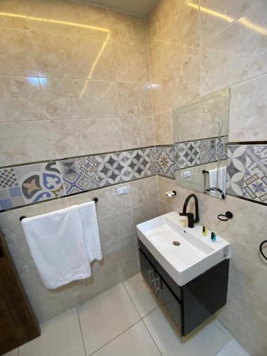 a bathroom with a sink and a mirror at AB pyramids view in Cairo