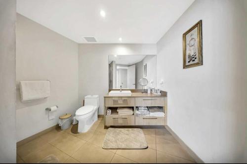 a white bathroom with a toilet and a sink at Beautiful Beach front condo with Top Amenities in Hollywood