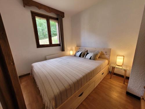 a bedroom with a large bed with two lamps at Appartements Ski Spa & Confort Orelle-3 vallées in Orelle