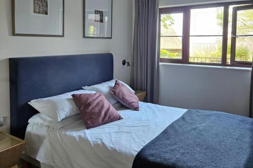 a bedroom with a bed with two pillows on it at 2br-sleeps4-pool-freeparking-trenythonestate in Par