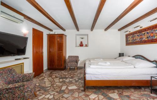 a bedroom with a bed and a flat screen tv at Holiday Home Villa Laura - Krk by Villas Guide in Krk