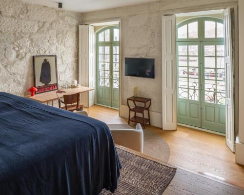 a bedroom with a bed and a table and chairs at The House of Sandeman in Vila Nova de Gaia
