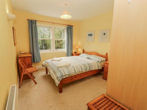 ein Schlafzimmer mit einem Bett und einem Fenster in der Unterkunft Flat 17 Greta Grove in Keswick