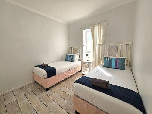 a bedroom with two beds and a window at Dolphin Nook 29 in Gqeberha
