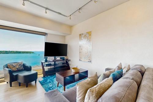 a living room with a couch and a tv at Newmark Bayview Luxury Suite in Seattle