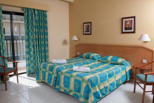 a bedroom with a bed with two towels on it at EUROCLUB Hotel in St. Paul's Bay