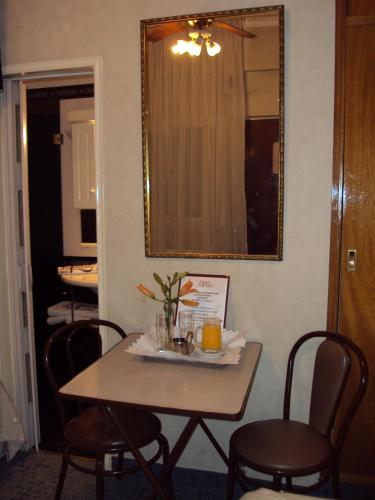 a table and chairs in a room with a mirror at Hotel Rey in Buenos Aires