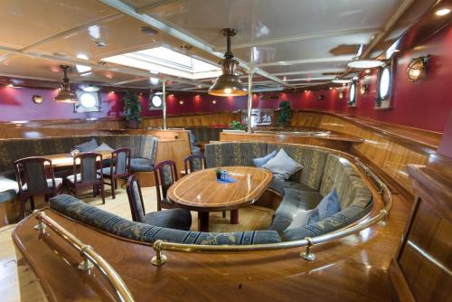un restaurant avec une table et des chaises en bois dans l'établissement Tallship Artemis, à Bremerhaven