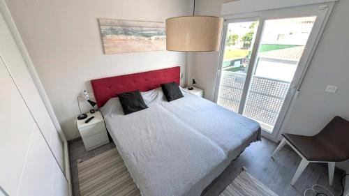 1 dormitorio con 1 cama con cabecero rojo y ventana en Casa Isabel in El Verger, en El Verger