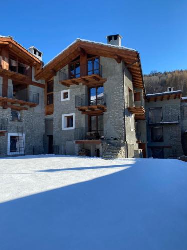 un edificio de apartamentos con nieve delante en La Baita del vecchio GAD, en Oulx