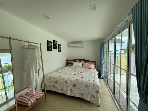 a bedroom with a bed and a balcony at บ้านสวนแสงหล้า วิลล่า รีสอร์ท 