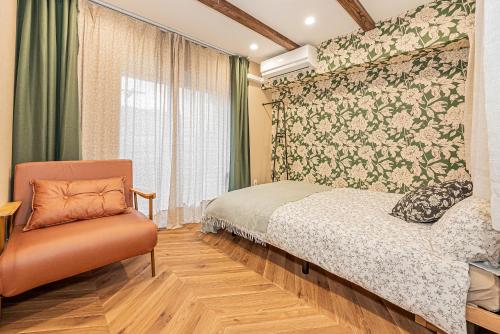 Un dormitorio con una cama y una silla y una ventana. en Lions Mansion Kabukicho No2, en Tokio