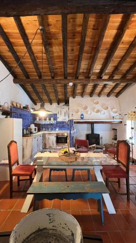 a kitchen with a table and chairs in a kitchen at Monte da Freira in Bencatel