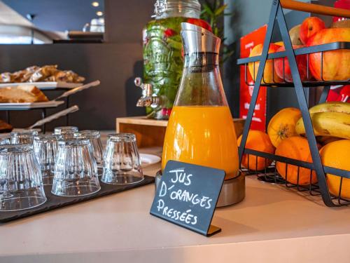 una botella de zumo de naranja sentada encima de un mostrador en Ibis Alès Centre Ville, en Alès